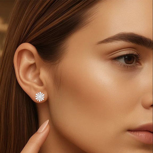 Close-up of a woman wearing a silver earring with a floral design.