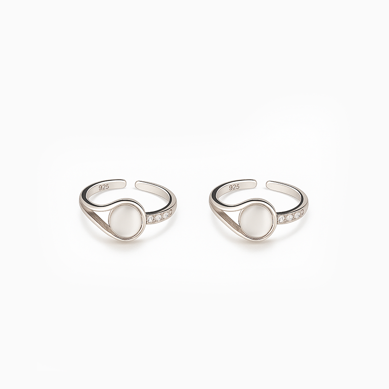 Pair of silver open rings with moonstone stones on a white background