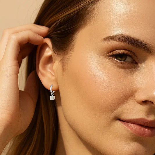 Close-up of a woman wearing earrings with a neutral background