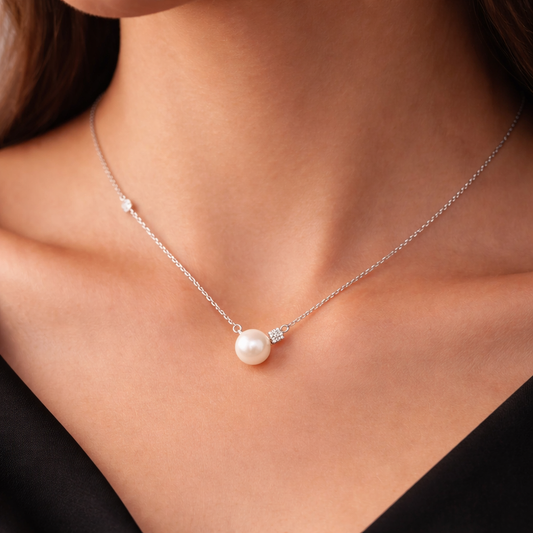 Pearl necklace with a silver chain on a person wearing a black top.