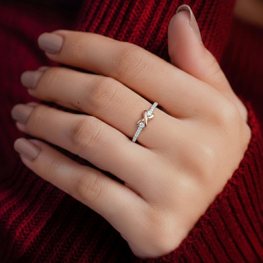 Close-up of a hand wearing a silver ring with a diamond on a red textured background
