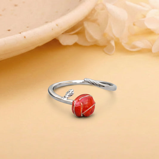 Silver ring with a red stone on a beige background