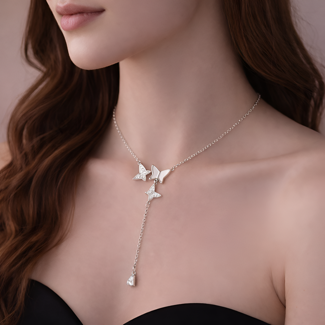 Butterfly necklace worn by a model with a neutral background