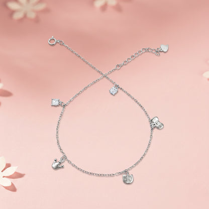 Silver anklet with heart-shaped charms on a pink floral background