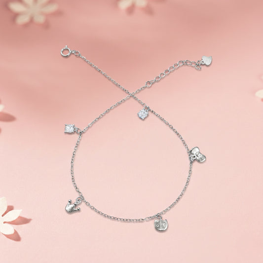 Silver anklet with heart-shaped charms on a pink floral background