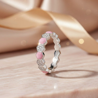 Silver ring with pink and white gemstones on a soft beige background