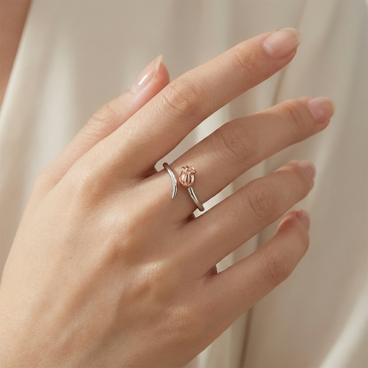 Hand wearing a rose gold ring with a subtle design on a neutral background