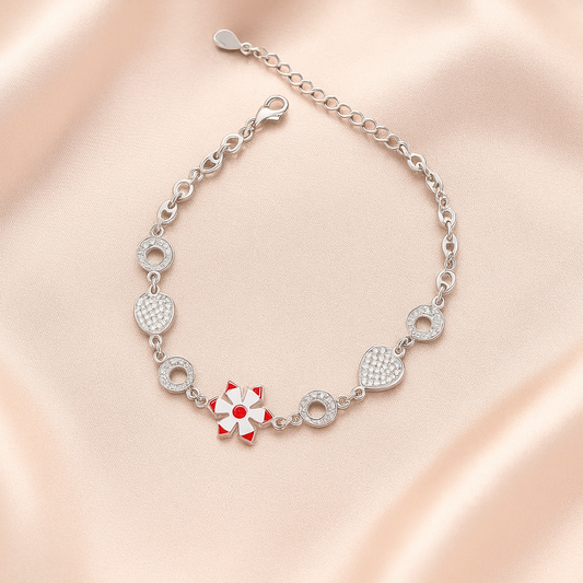 Silver bracelet with a red flower charm on a pink satin background
