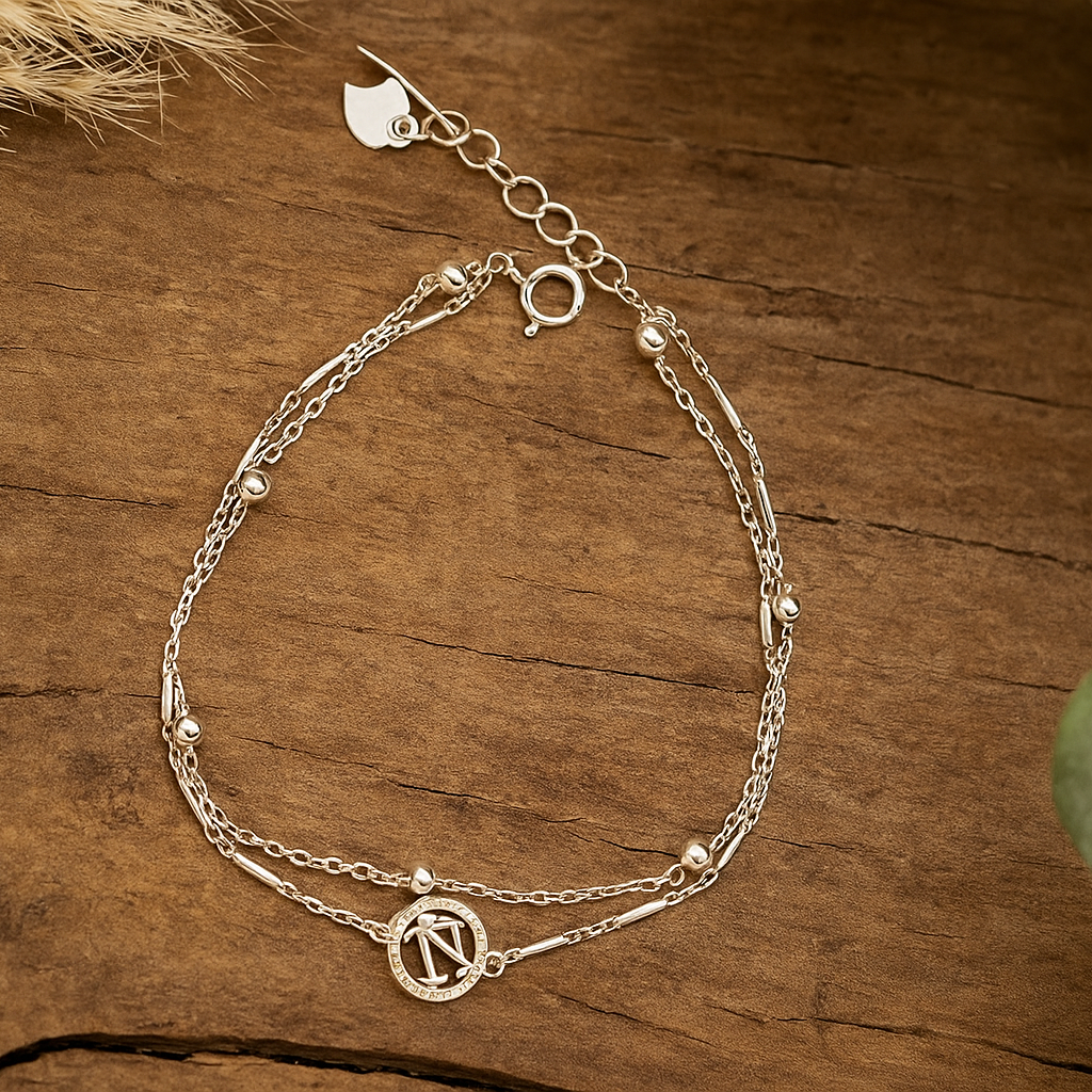Silver bracelet with chain design on a wooden surface