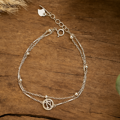 Silver bracelet with chain design on a wooden surface