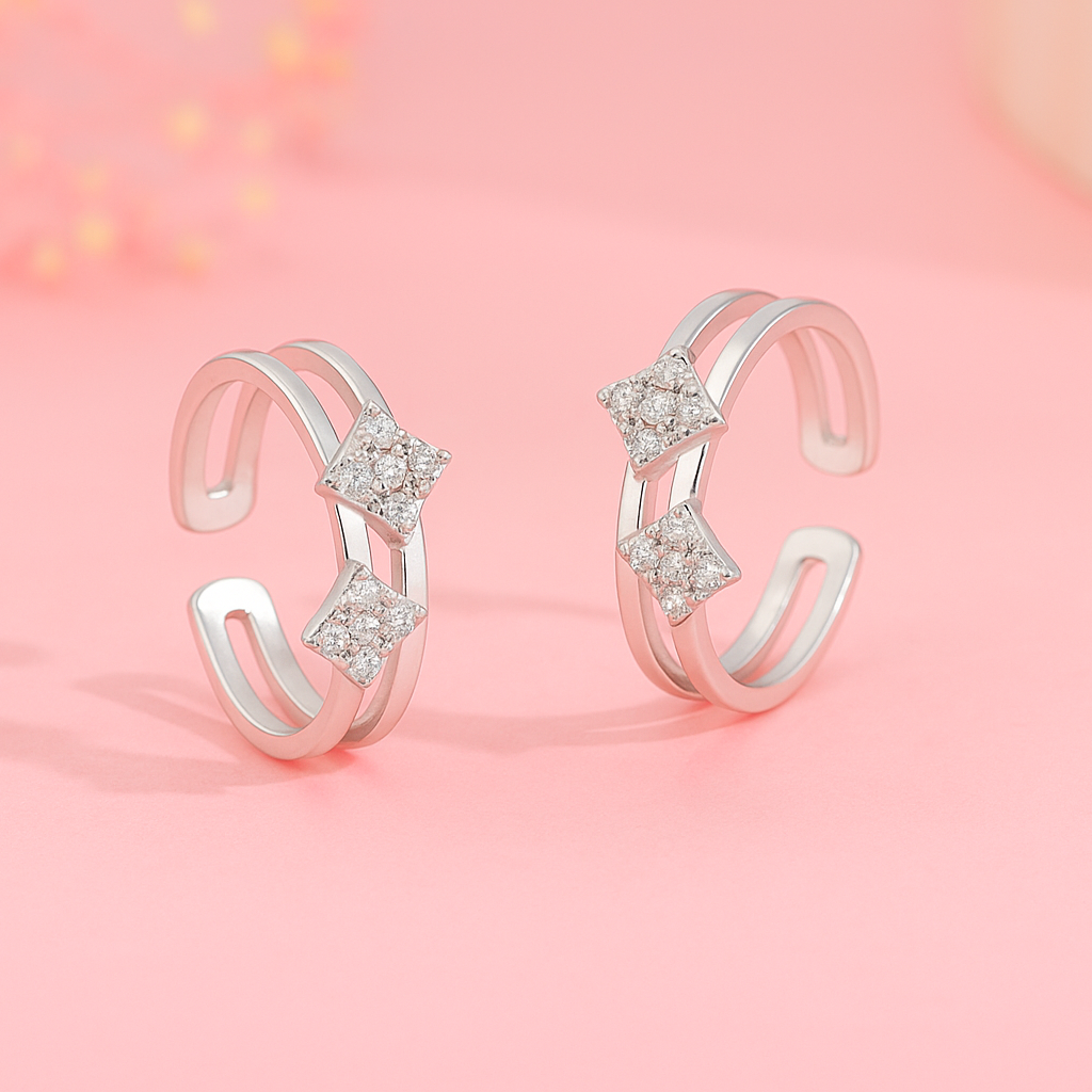 Pair of silver open rings with star-shaped gemstones on a pink background