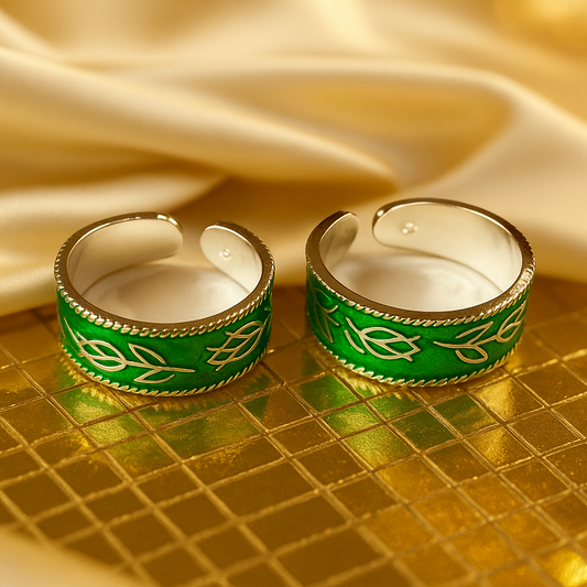 Two green and gold rings on a gold surface