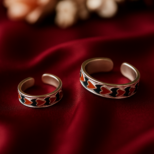 Two silver open rings with colorful patterns on a red fabric background