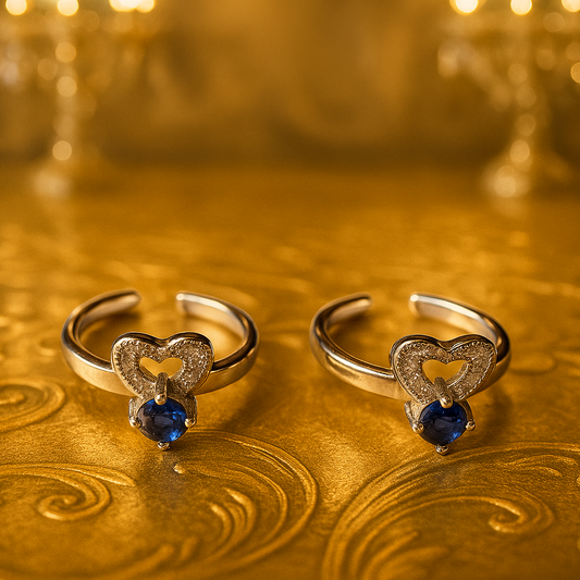Two heart-shaped rings with blue gemstones on a gold background