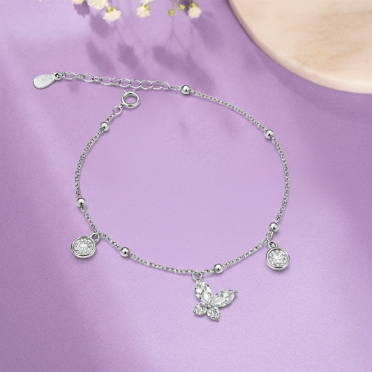 Silver bracelet with a butterfly charm on a purple background