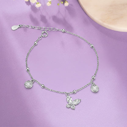 Silver bracelet with a butterfly charm on a purple background