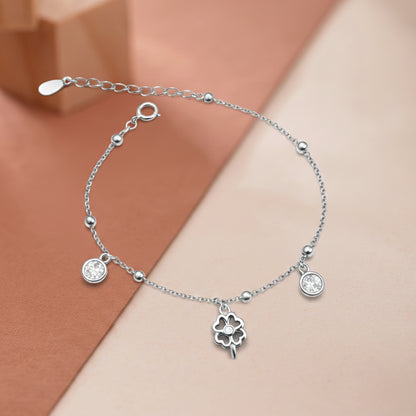 Silver bracelet with clover charm on a two-tone background