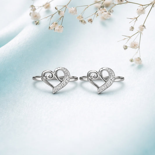 Heart-shaped silver rings on a light blue background with delicate flowers.