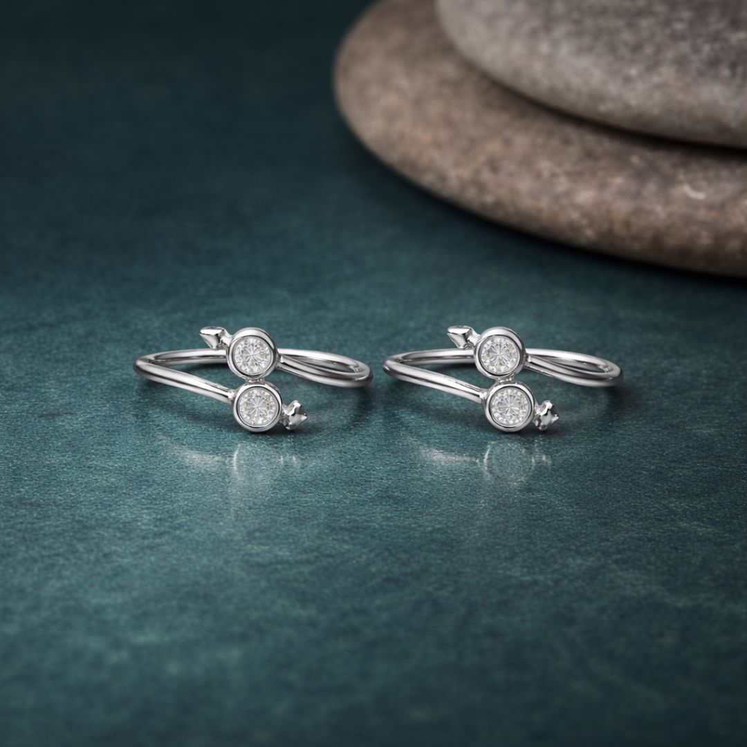 Two silver rings with gemstones on a textured green surface