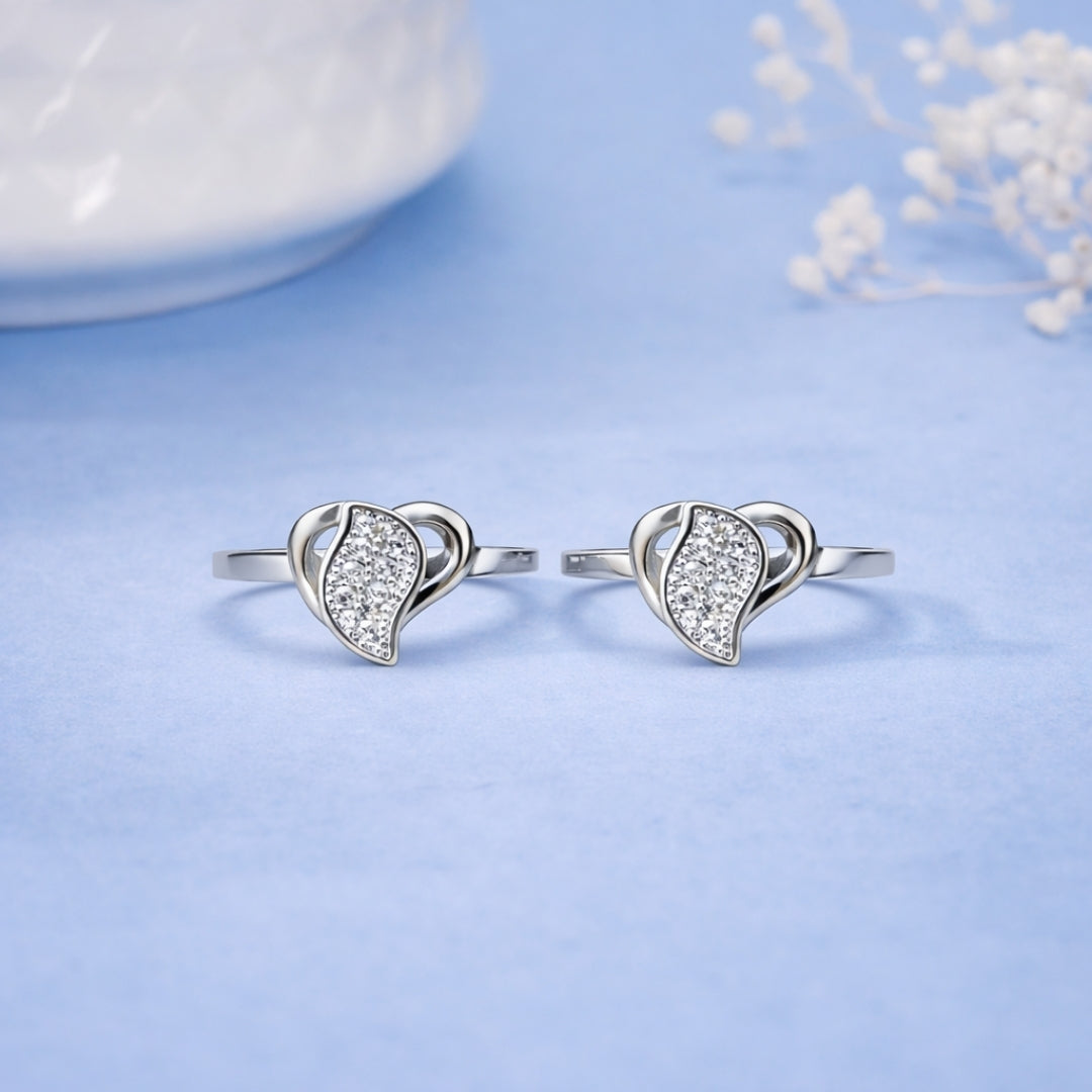 Heart-shaped silver earrings on a light blue background