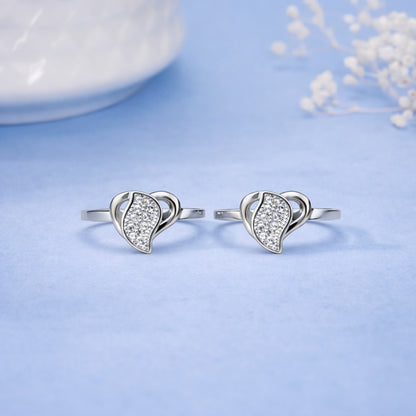 Heart-shaped silver earrings on a light blue background