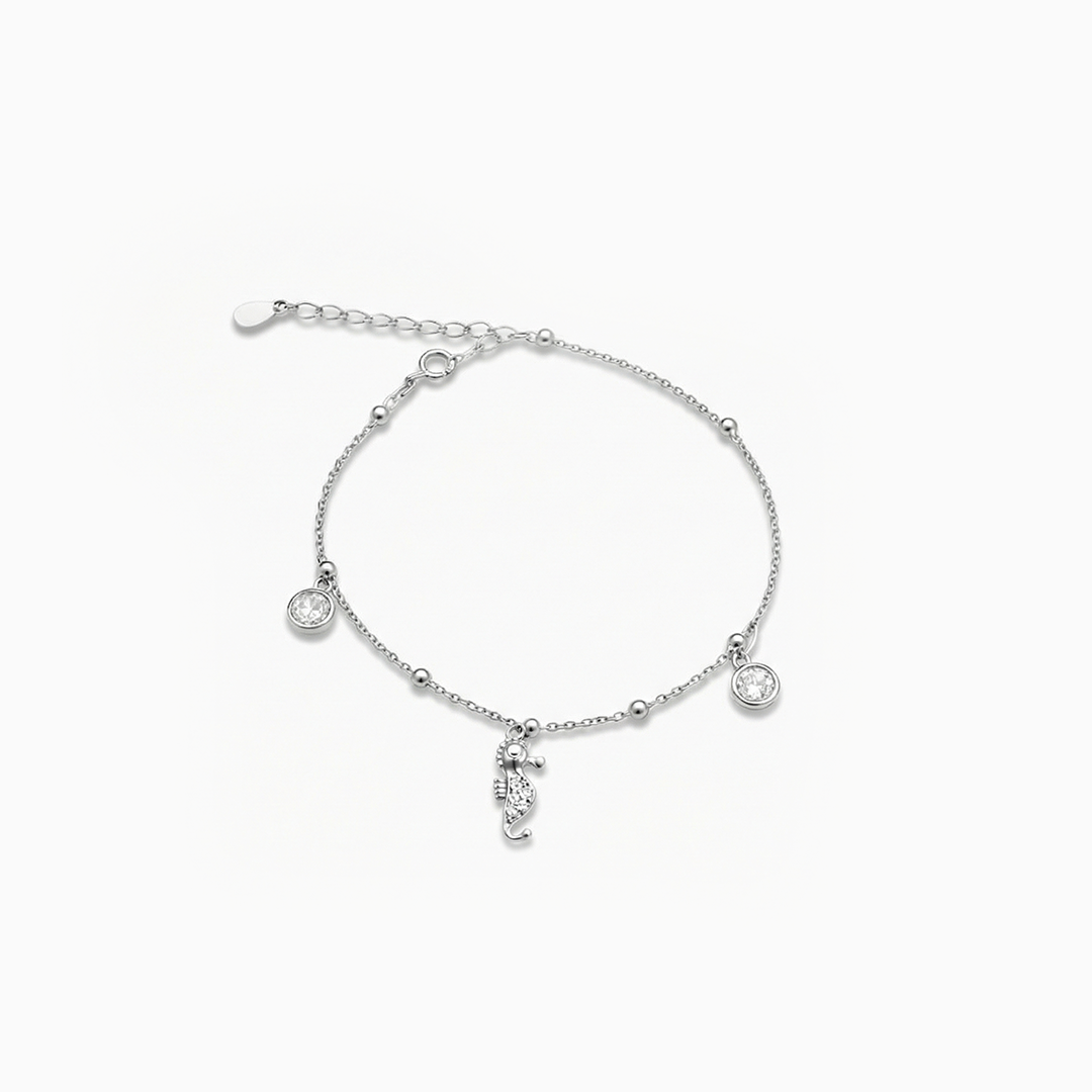 Silver anklet with small round pendants on a white background