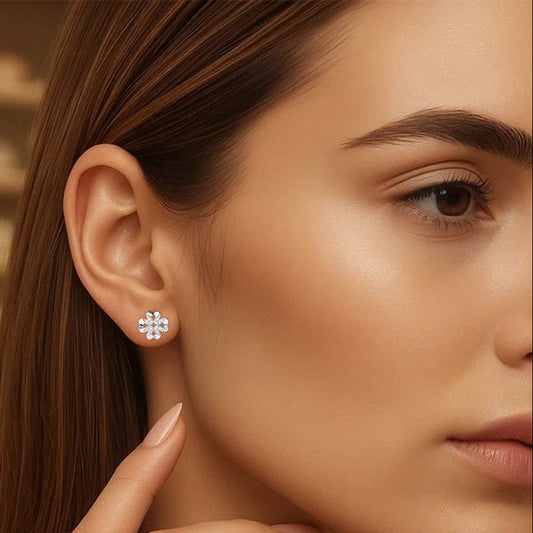 Close-up of a woman wearing silver stud earrings with a blurred background