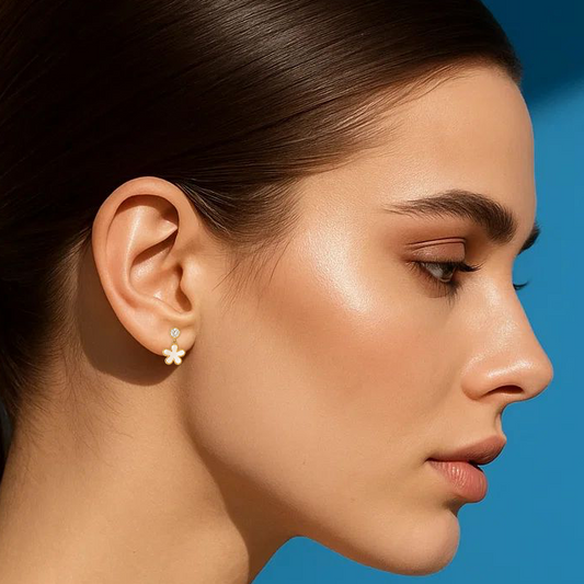 Woman wearing a floral earring against a blue background