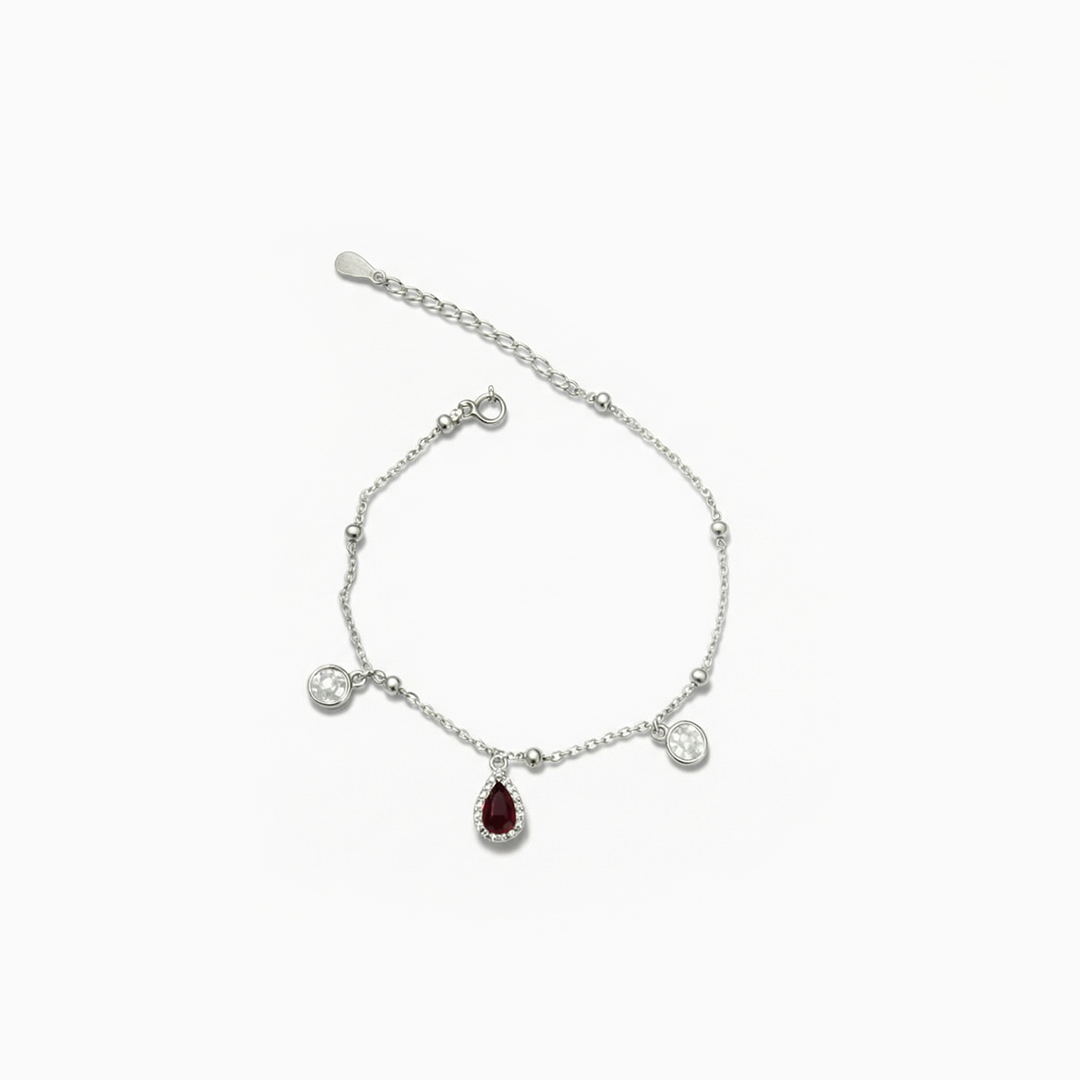 Silver bracelet with a red gemstone on a white background