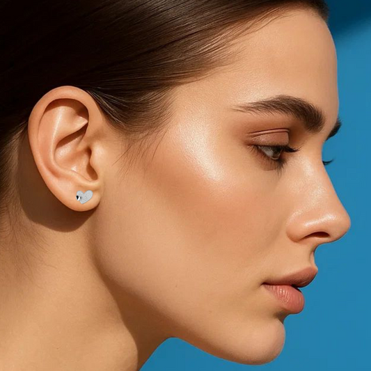 Woman wearing diamond earrings against a blue background