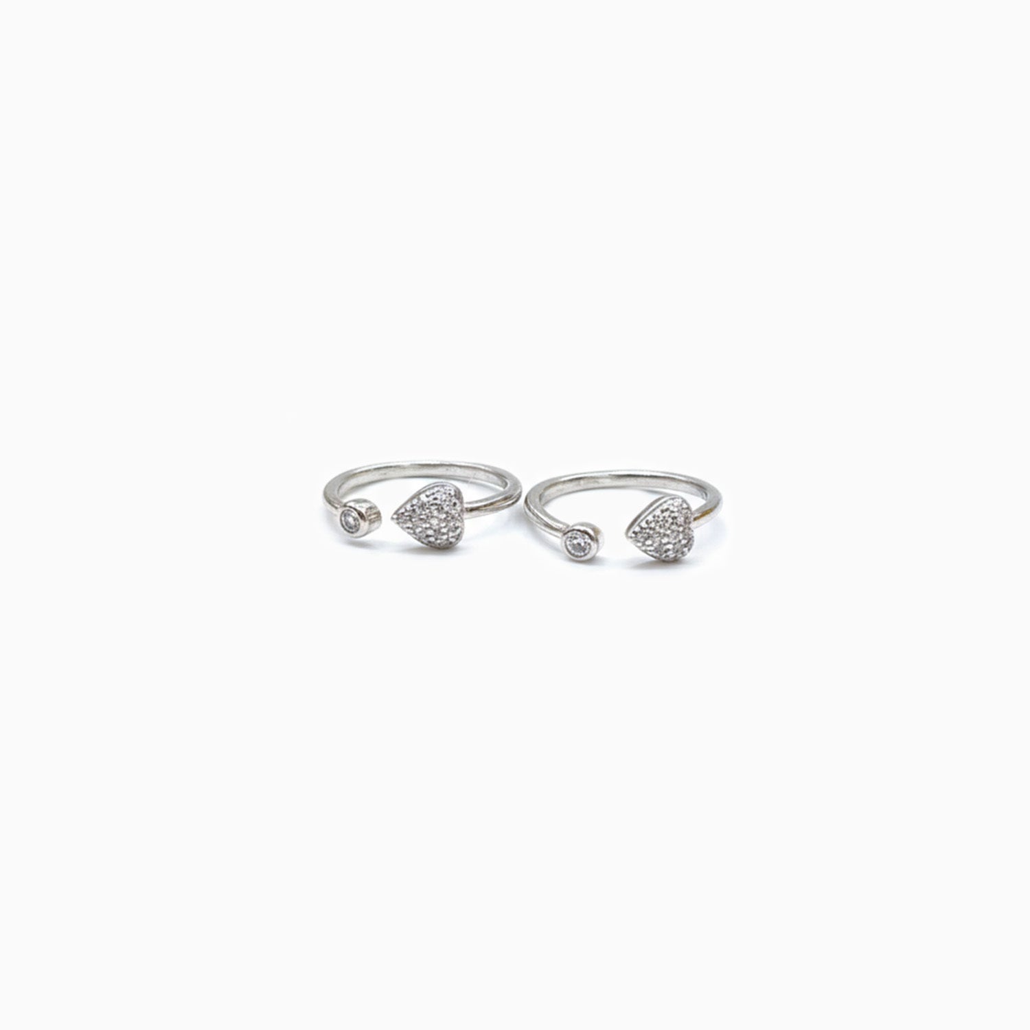 Pair of silver open rings with heart designs on a white background