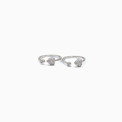 Pair of silver open rings with heart designs on a white background