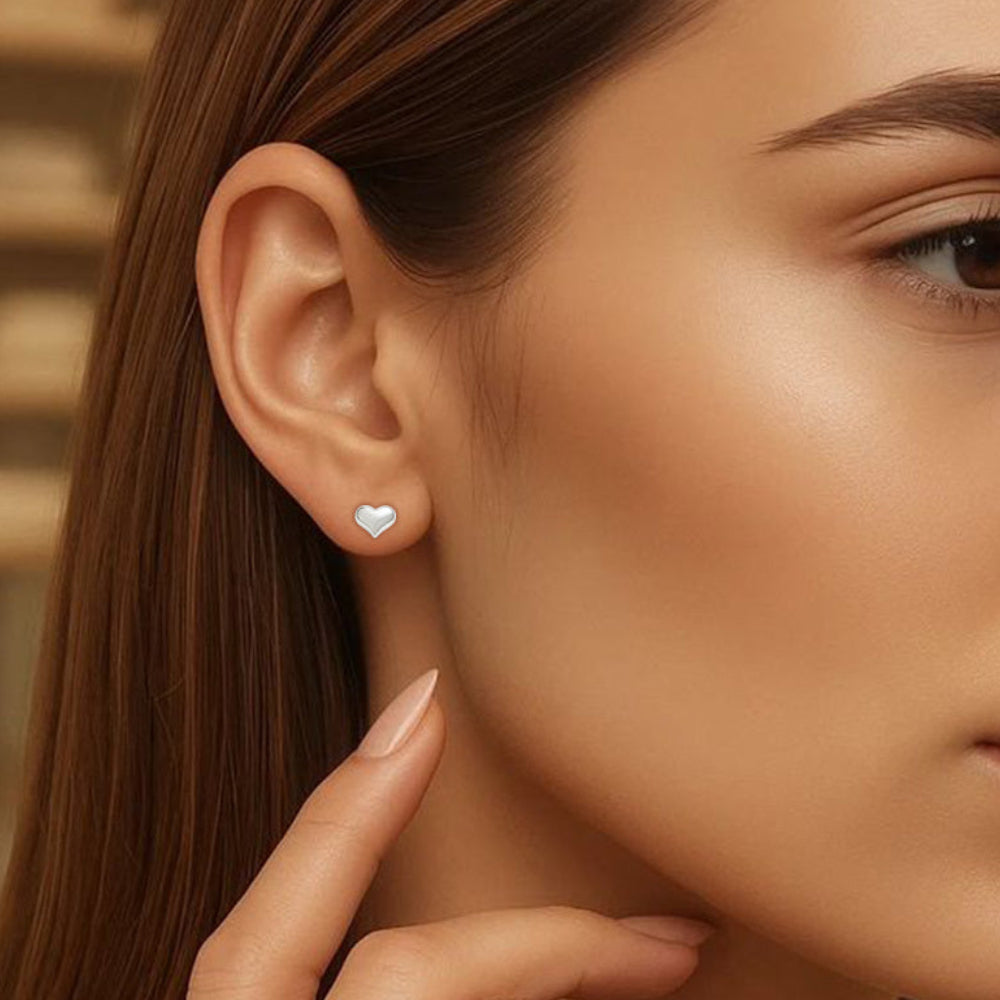 Close-up of a woman wearing a heart-shaped earring with a blurred background