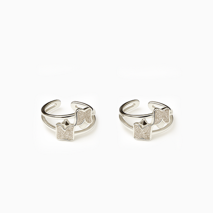 Pair of silver open rings with diamond-like stone accents on a white background