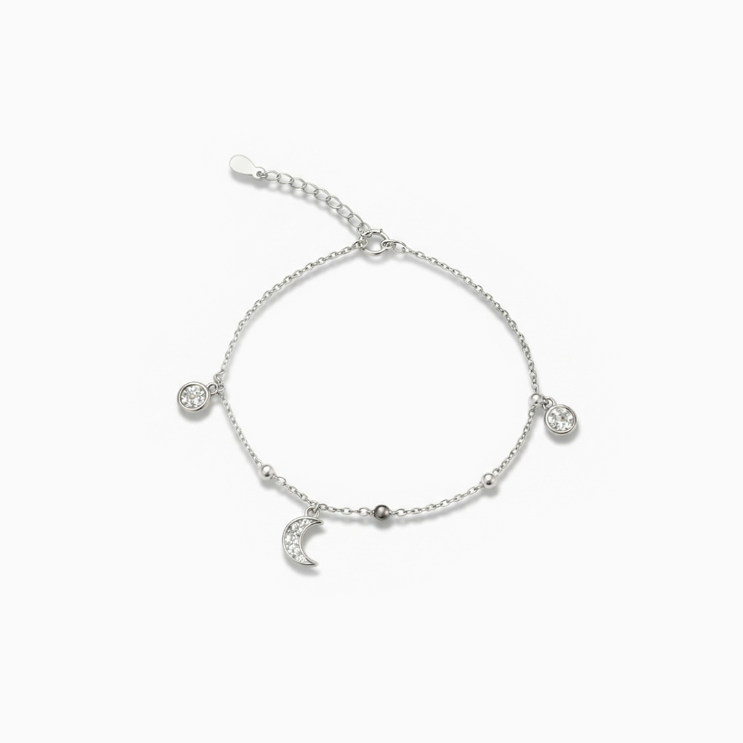 Silver bracelet with heart and moon charms on a white background