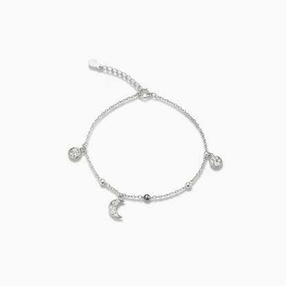 Silver bracelet with heart and moon charms on a white background