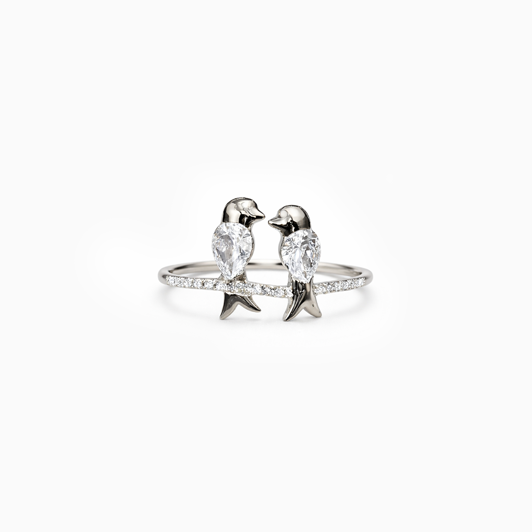 Silver ring with bird-shaped designs on a white background