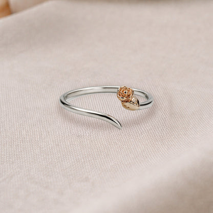 Silver ring with a rose gold accent on a beige fabric background