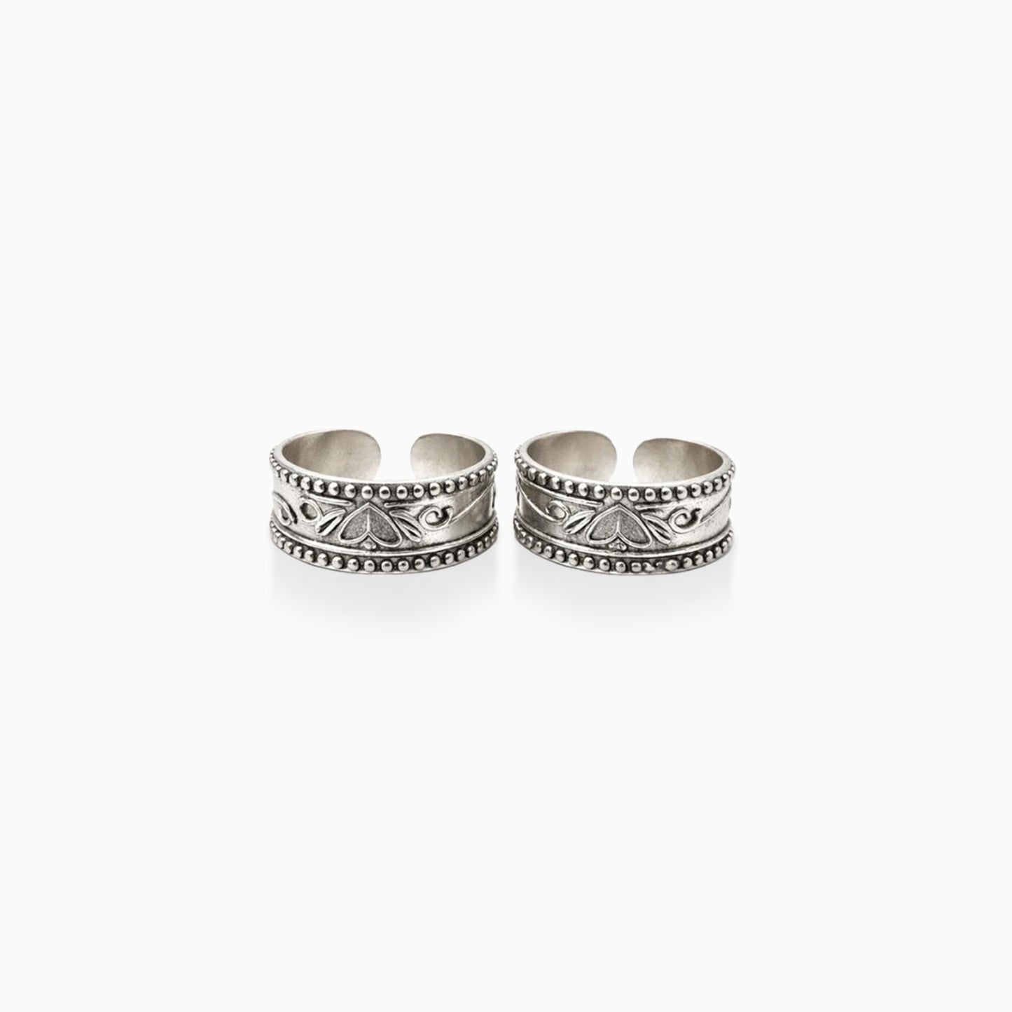Two silver toe rings with intricate designs on a white background