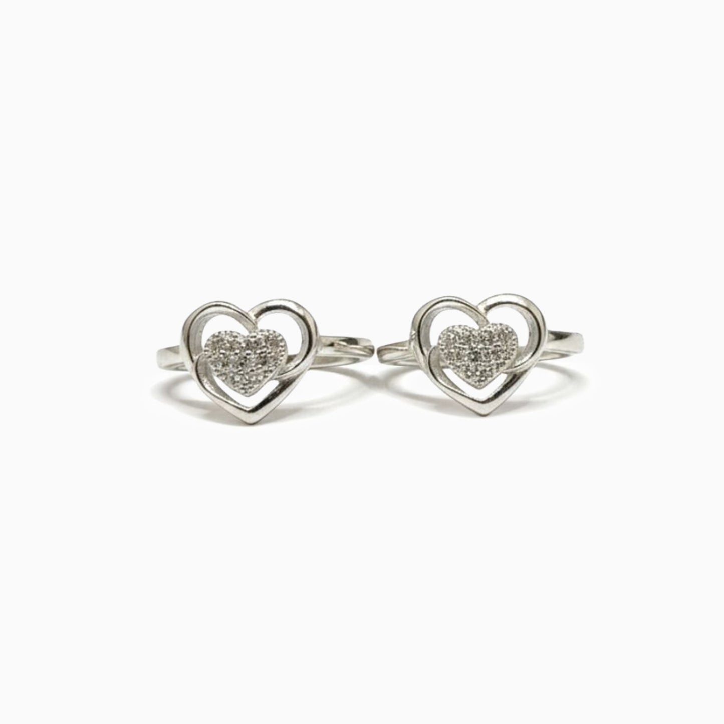 Pair of silver heart-shaped rings with embedded stones on a white background