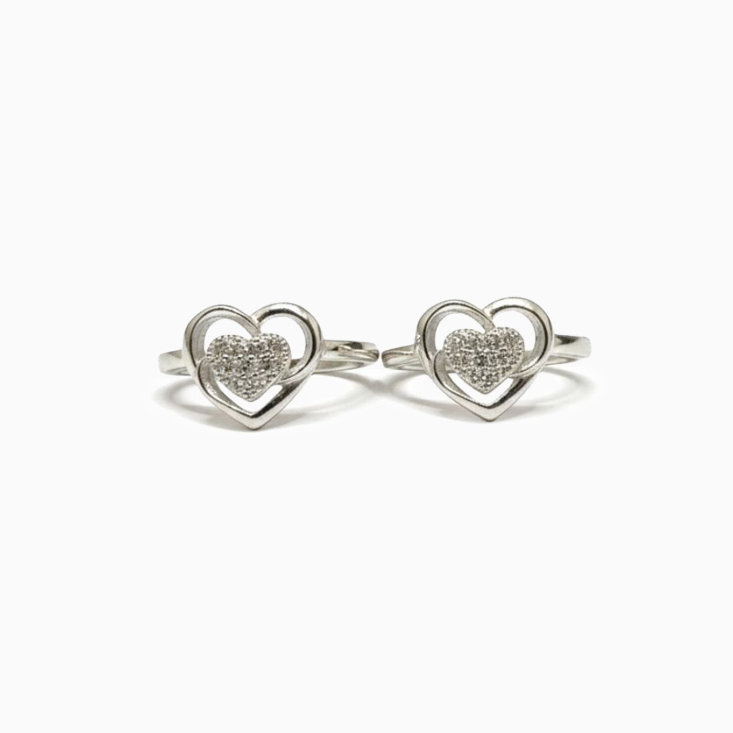 Pair of silver heart-shaped rings with embedded stones on a white background