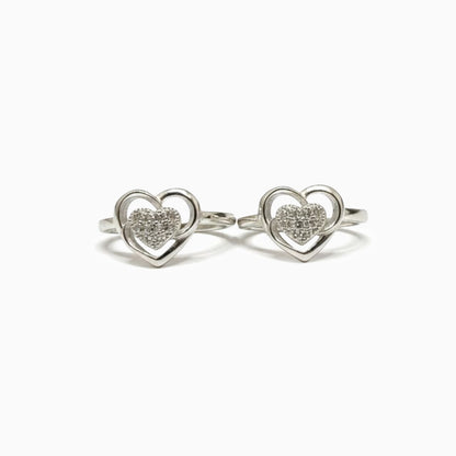 Pair of silver heart-shaped rings with embedded stones on a white background
