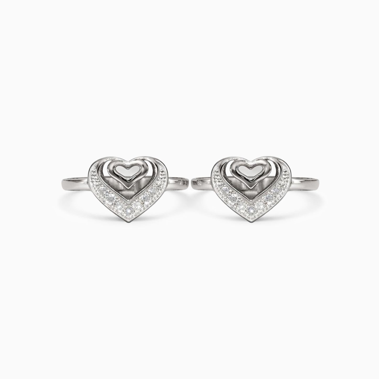 Pair of silver heart-shaped rings on a white background