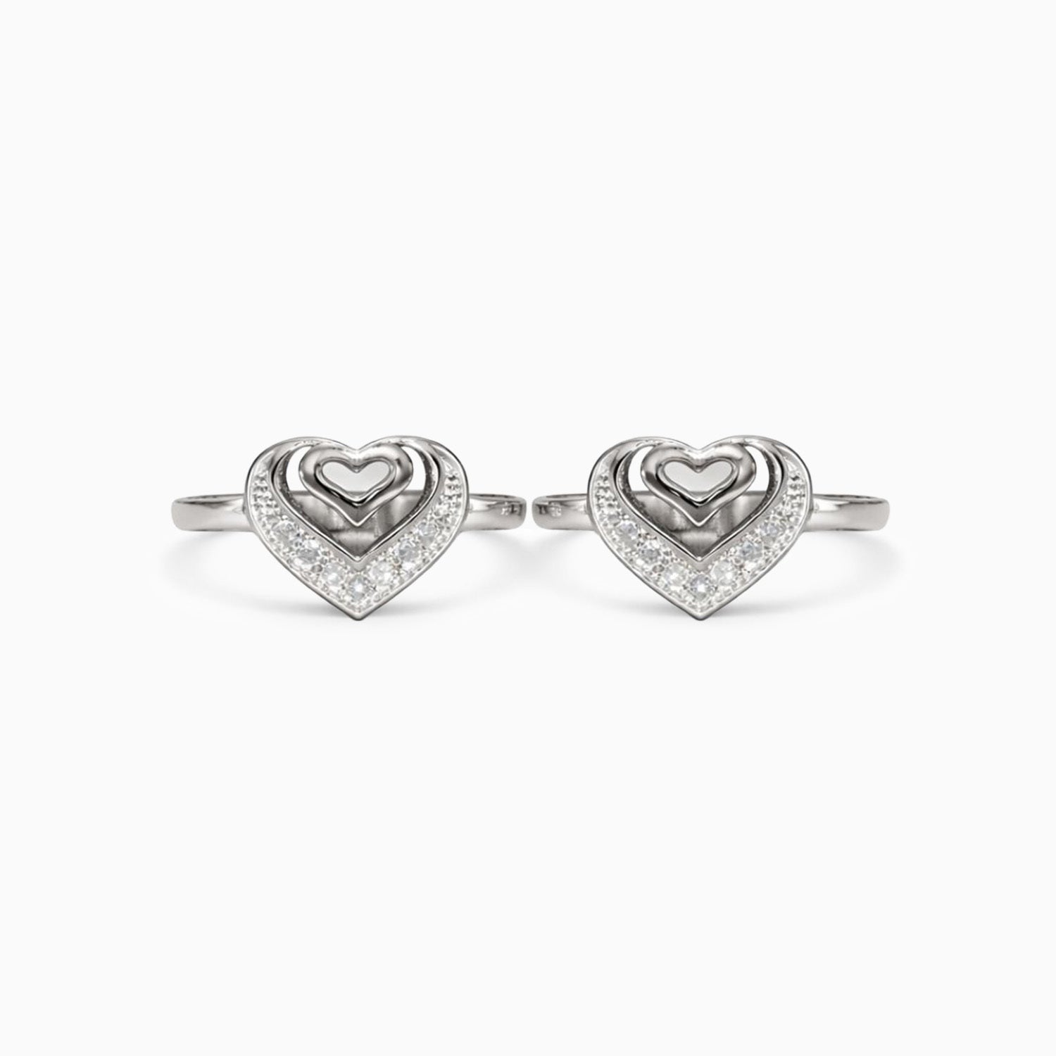Pair of silver heart-shaped rings on a white background