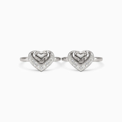 Pair of silver heart-shaped rings on a white background