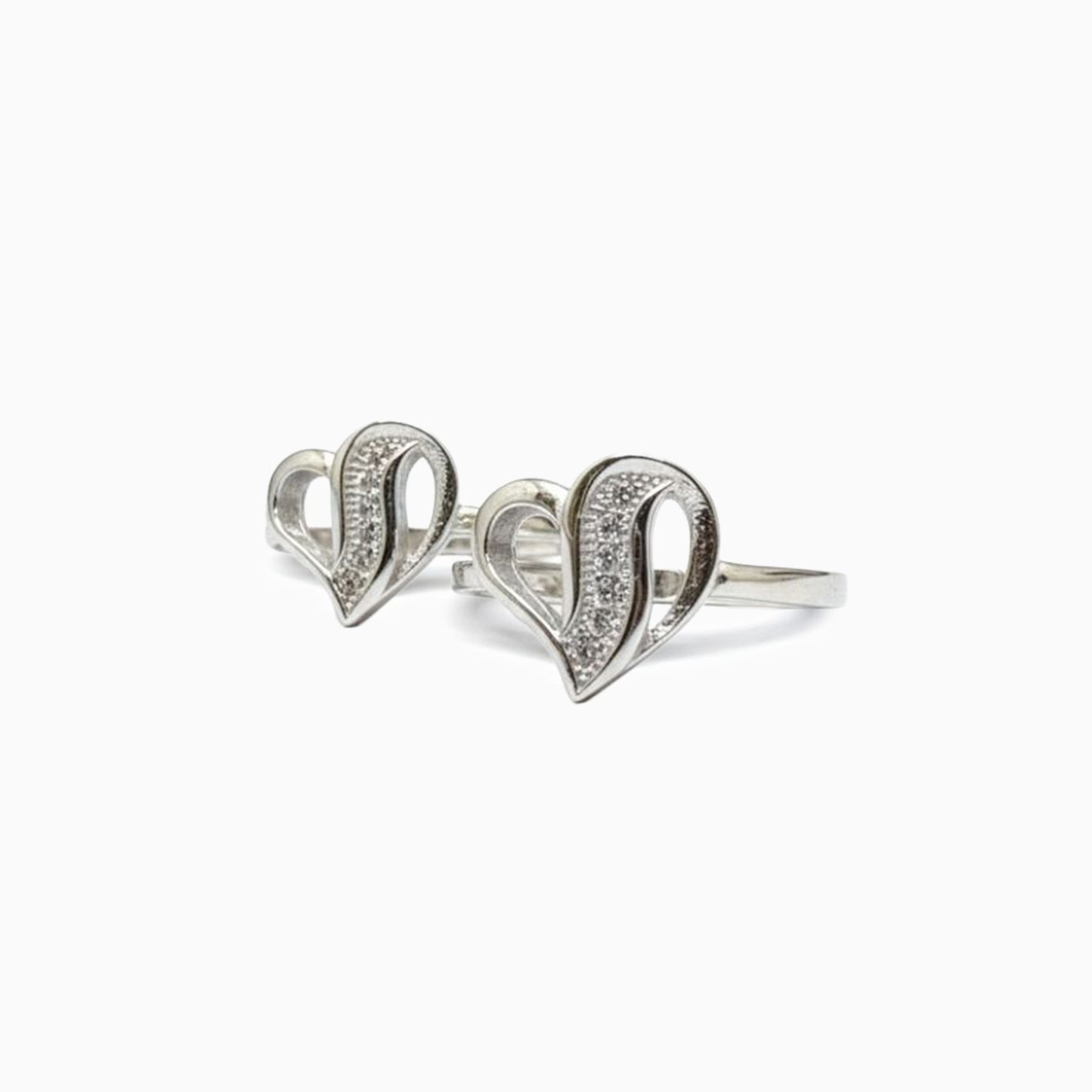 Silver heart-shaped ring with embedded stones on a white background