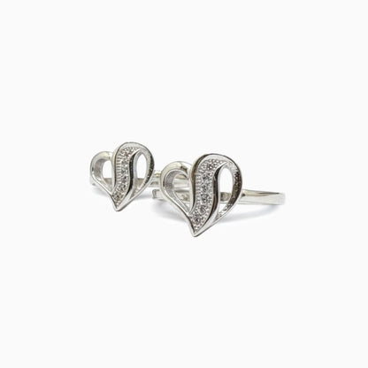 Silver heart-shaped ring with embedded stones on a white background