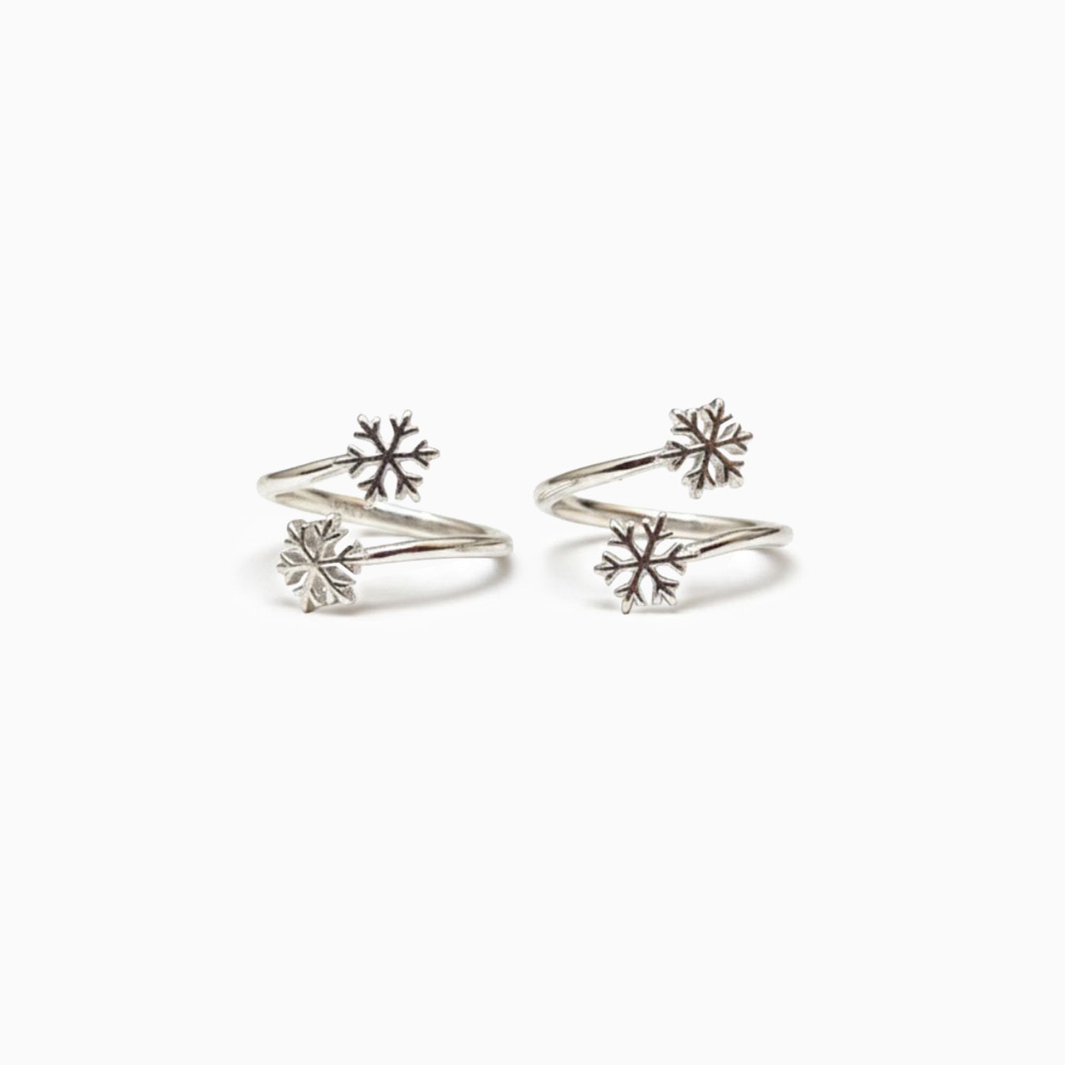 Pair of silver snowflake-shaped earrings on a white background