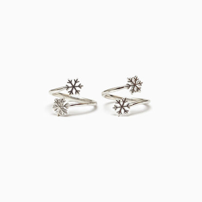 Pair of silver snowflake-shaped earrings on a white background