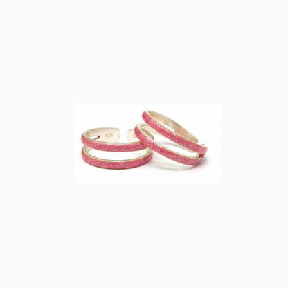 Three pink glittery rings on a white background